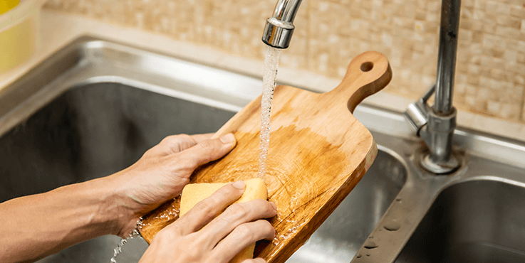 Woman washing chopping board