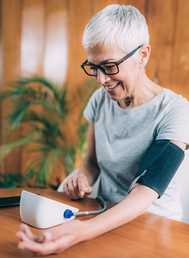 senior woman measuring her blood pressure at home