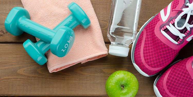 Items depicting a health fitness lifestyle, including hand weights, trainers, an apple and a bottle of water.