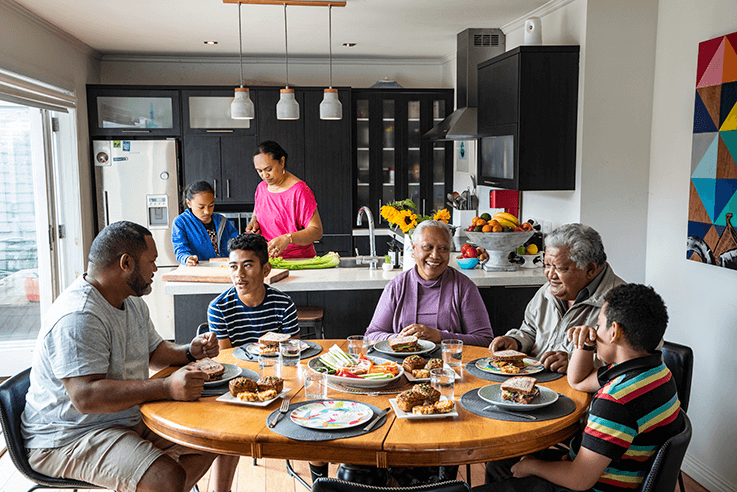 Large Pasifika family enjoying a meal together